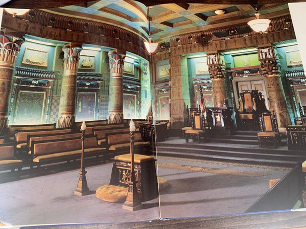 Color photograph across a two-page spread showing an ornate lodge room decorated in elaborate Egyptian Revival style architecture.